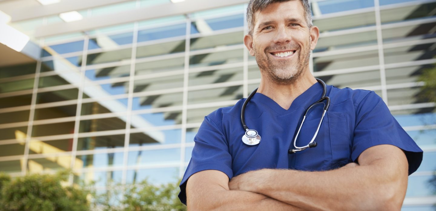 Happy male healthcare worker smiling to camera outdoors